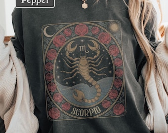 May include: Dark gray t-shirt with a Scorpio zodiac design. The graphic features a scorpion, surrounded by roses, a crescent moon, and a sun. The word "SCORPIO" is at the bottom. The brand name "Pepper" is in the upper left corner.