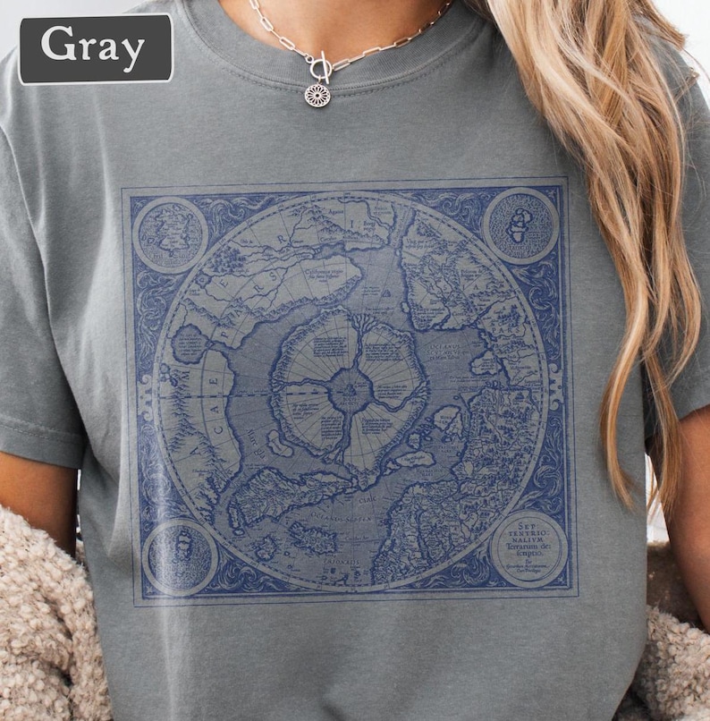 May include: A gray t-shirt with a vintage map of the world printed on the front. The map is in blue and white and features a circular design with a compass rose in the center. The text "THE TERRITIO WALTERE BYRONIS DE EMPIRE" is printed at the bottom of the map.