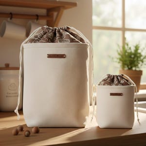 May include: A set of three ceramic mugs with a speckled, matte finish. Each mug features a different color: light blue, cream, and gray. The mugs have a simple, modern design and a comfortable handle.