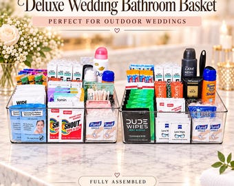 May include: Two clear plastic organisers filled with assorted personal care items including Dove deodorant, Shout stain remover wipes, Purell hand sanitiser, Dude Wipes, TRESemmé hair spray, and Banana Boat sunscreen. Text reads Deluxe Wedding Bathroom Basket.