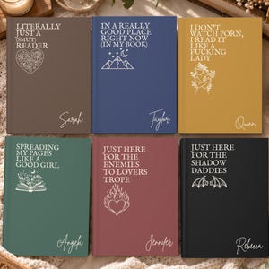 May include: Six hardcover journals in brown, blue, mustard, green, maroon, and black, each featuring white text and line art illustrations. The covers display phrases like 'Literally Just A Smut Reader' and 'Just Here For The Shadow Daddies' with personalized names.
