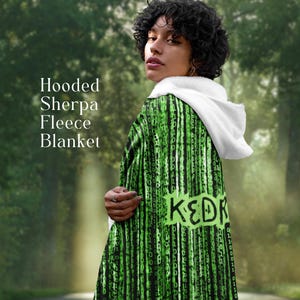 Può includere: Una coperta con cappuccio in pile sherpa con cappuccio bianco e un motivo a pioggia digitale verde e nero. La coperta ha la parola "KEDR" in verde sul retro. Il testo "Hooded Sherpa Fleece Blanket" è sul lato sinistro.