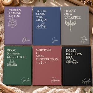 Può includere: Sei diari con copertina rigida in viola, blu, grigio, verde, bordeaux e nero. Ognuno presenta testo bianco e disegni a linee, incluse frasi come I've Been Looking For You, To The Stars Who Listen e In My Bat Boys Era con nomi personalizzati.