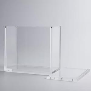 Puede incluir: Una caja de acrílico transparente con tapa extraíble. La caja es rectangular y tiene un diseño moderno y minimalista. La tapa es plana y queda al ras de la parte superior de la caja cuando está cerrada. Adecuada para exhibición o almacenamiento.