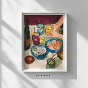 Puede incluir: Una impresión artística enmarcada de una naturaleza muerta. La pintura representa una mesa con bebidas, comida y limones. La paleta de colores incluye azules, rojos, amarillos y verdes. El texto "PULP & FRAME" está en la parte inferior.