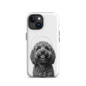 May include: A white phone case with a black and white image of a smiling dog. The dog has curly fur and a collar. The phone case has cutouts for the camera and buttons.