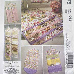 May include: A sewing pattern for a hanging jewelry organizer. The pattern includes three different designs: a long, rectangular organizer with a floral print, a smaller, rectangular organizer with a purple and yellow floral print, and a hanging organizer with multiple pockets. The pattern is titled "Nancy Zieman ten twenty thirty minutes to sew" and includes step-by-step instructions.