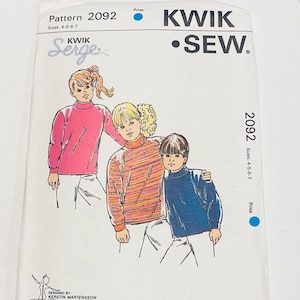 May include: A Kwik Sew pattern envelope, featuring illustrations of three children wearing turtleneck sweaters. The pattern number is 2092, with sizes 4-5-6-7. The text "KWIK SEW" and "Serge" are also visible.