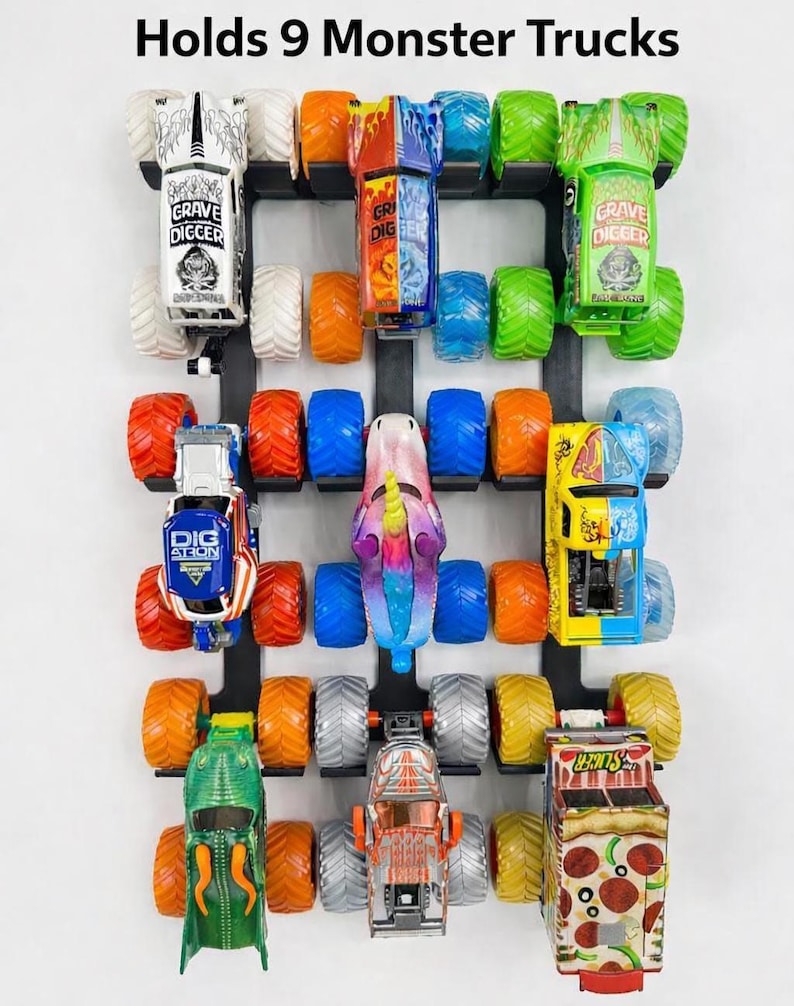 Puede incluir: Un estante de exhibici&oacute;n negro montado en la pared que contiene nueve camiones monstruo de juguete. Los camiones son de varios colores, incluyendo verde, naranja, azul y amarillo, con gr&aacute;ficos detallados y neum&aacute;ticos grandes. El texto "Holds 9 Monster Trucks" est&aacute; en la parte superior.