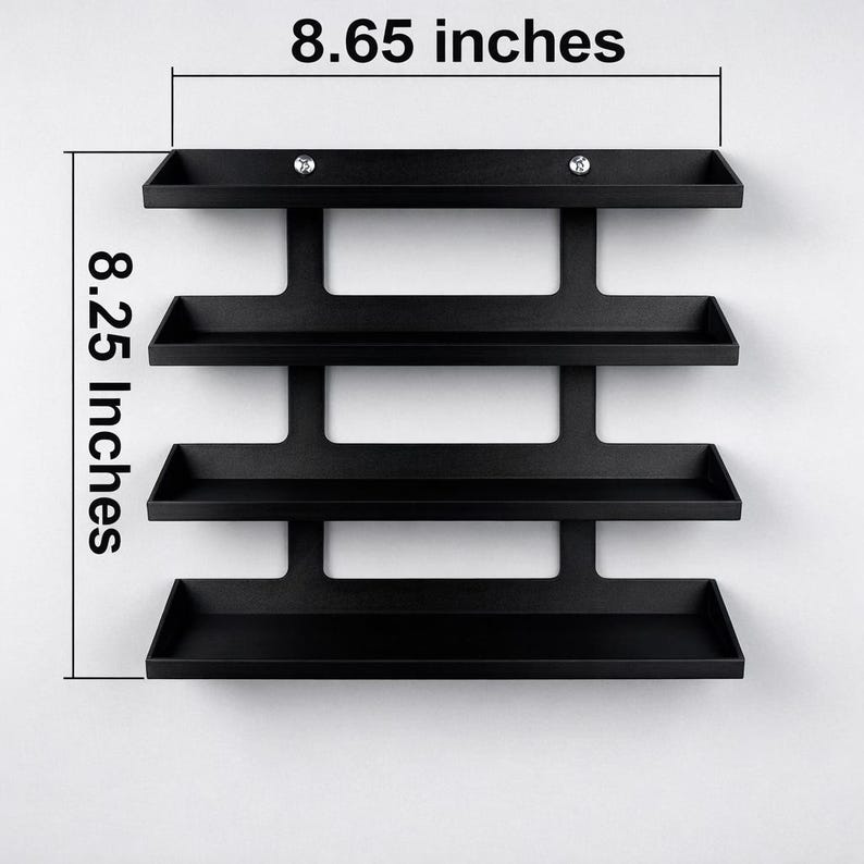 May include: A black, wall-mounted shelf unit with four tiers. The unit is 8.65 inches wide and 8.25 inches tall. The shelves are rectangular and have a small lip to prevent items from falling off. Two small, decorative accents are visible.