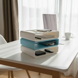 Puede incluir: Una pila de tres organizadores de escritorio modernos en blanco y azul claro. Los organizadores superior e inferior son blancos, mientras que el del medio es azul claro. Cada estante contiene &uacute;tiles de oficina. Los organizadores est&aacute;n sobre un escritorio blanco.