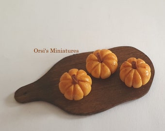 Dollhouse miniature small pumpkin breads on aged wooden board in 1 inch scale