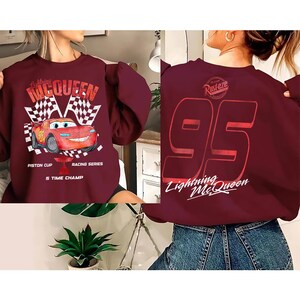 May include: A white ceramic mug with a black handle and the text "But First, Coffee" in a black, handwritten-style font. The mug is on a white surface.