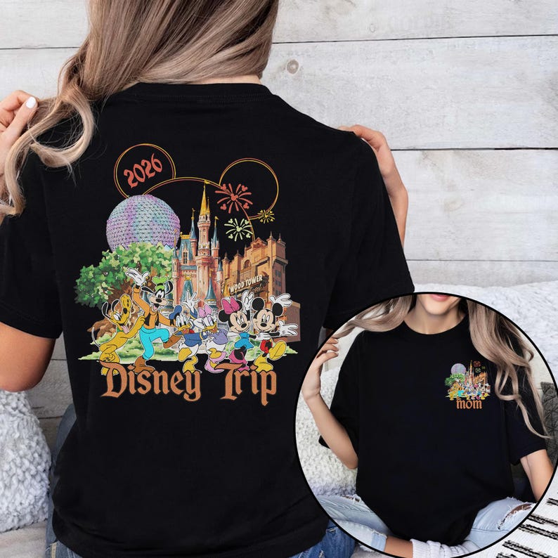 May include: Black t-shirt featuring a colorful Disney Trip design with Mickey Mouse, Minnie Mouse, and other characters. The design includes the text "2026" and a smaller design on the front that says "mom".
