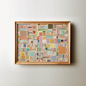 Könnte beinhalten: Abstrakter Kunstdruck in einem Holzrahmen. Das Kunstwerk zeigt ein farbenfrohes geometrisches Design mit verschiedenen Formen und Größen in den Farbtönen Rosa, Orange, Blau, Grün und Gelb. Der Rahmen ist hellbraun.