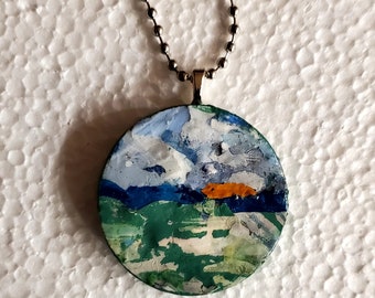 Blue skies and green fields is an original,OOAK, handpainted wooden pendant/necklace. Abstract green fields under a sunset sky. Wearable art