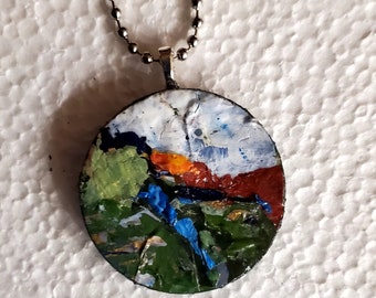 Sunset stream is an original, OOAK,handpainted wooden pendant/necklace.  Blue skies, red rocks, green fields and a cool stream Wearable art.