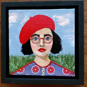 May include: A painting of a person wearing a red beret, round glasses with white dots, and a blue and red patterned shirt. The background is a blue sky with white clouds and green grass.