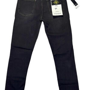 May include: Dark gray denim jeans with a classic five-pocket design. The jeans have a straight leg fit and a branded tag on the back pocket. The size tag reads "30".