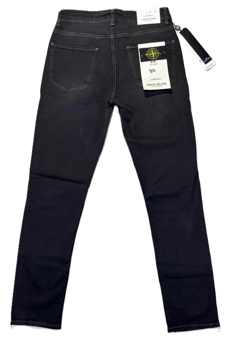 May include: Dark gray denim jeans with a classic five-pocket design. The jeans have a straight leg fit and a branded tag on the back pocket. The size tag reads "30".