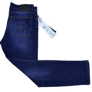 May include: Dark blue denim jeans with a classic five-pocket design. Features a logo patch on the back pocket and a leather patch at the waistband. Includes a size tag. A stylish and durable garment.
