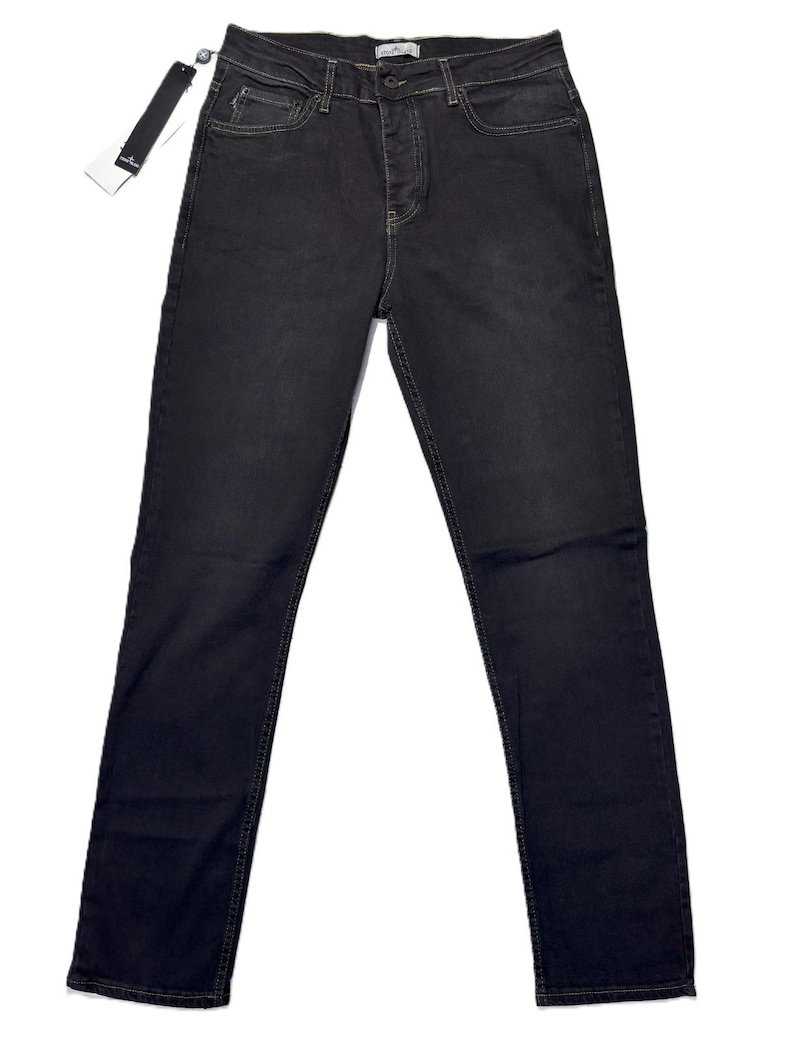 May include: Dark gray denim jeans with a classic five-pocket design. The jeans have a button and zipper closure, belt loops, and a straight leg fit. A black tag is attached to the jeans.