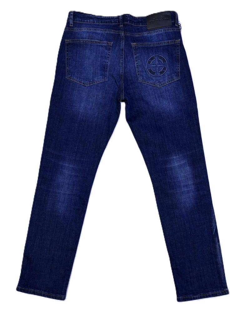 May include: Dark wash denim jeans with a classic five-pocket design. Features a black leather patch on the back waistband and a circular emblem on the back right pocket. The jeans have a straight leg cut.