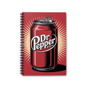 May include: Spiral-bound notebook featuring a stylized illustration of a Dr Pepper soda can. The can is a deep reddish-brown with the Dr Pepper logo in white. The background is a red burst design.