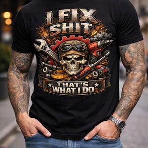 Puede incluir: Camiseta negra con un gráfico que presenta una calavera con gafas, herramientas y el texto "I FIX SHIT THAT'S WHAT I DO". El diseño incluye una llave inglesa, un destornillador y un taladro. La camiseta la lleva una persona con tatuajes y vaqueros.