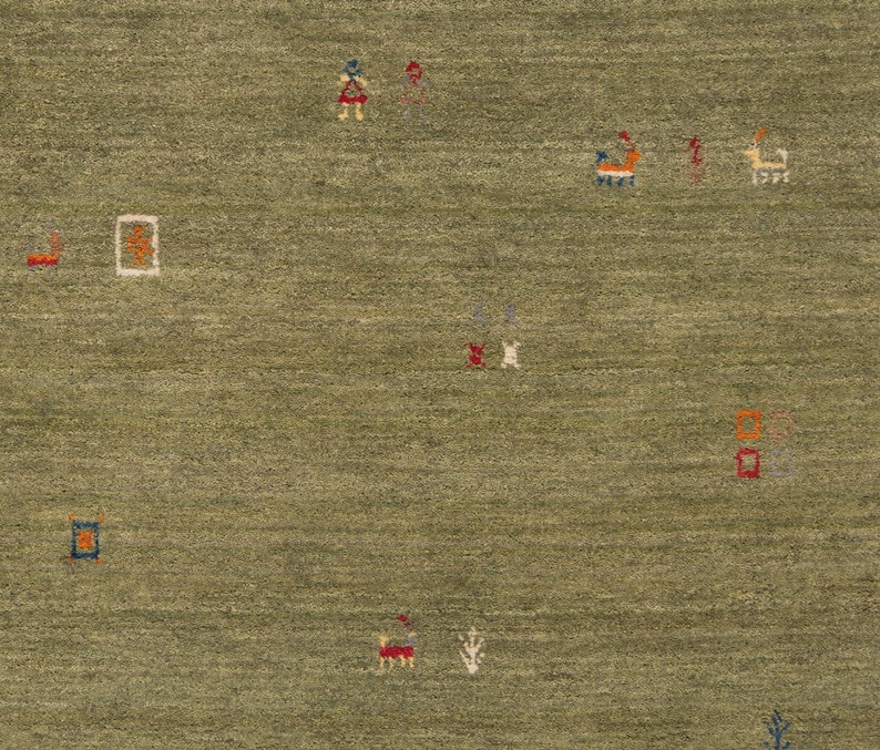 May include: A green area rug with a textured surface and scattered, colorful geometric designs. The rug features small squares, rectangles, and abstract shapes in shades of red, orange, blue, and white.