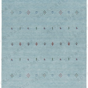 May include: A light blue rectangular rug with a repeating pattern of small geometric shapes and figures in red, green, and black. The rug has a simple, minimalist design, suitable for various interior styles.