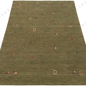 May include: A rectangular olive green rug with a subtle textured surface. The rug features scattered, colorful, abstract designs, including small squares, rectangles, and stylized figures in red, orange, and white.