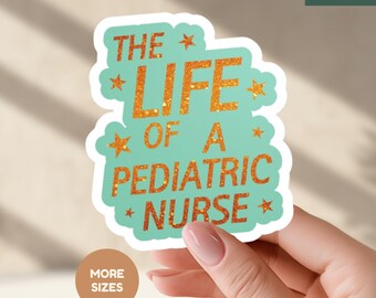May include: A sticker with the text "THE LIFE OF A PEDIATRIC NURSE" in orange glitter lettering on a teal background. The sticker has a white border and star accents. The Wildflower Dreams logo is in the top right corner.