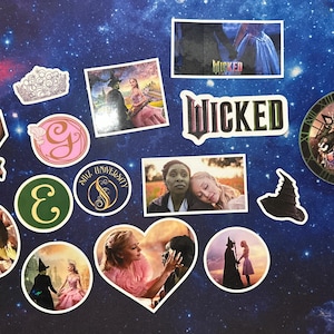 May include: A collection of stickers featuring imagery from the musical "Wicked." The stickers include images of characters, the show's logo, and a clock design. The stickers are arranged on a dark blue background with a starry pattern.