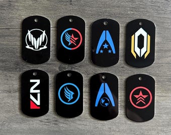 May include: Eight black dog tags with various white, blue, red, and yellow graphic designs. Each tag has a small hole at the top. The designs include stylized symbols and the letters "N7".