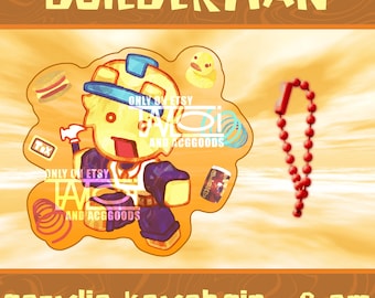 May include: An 8 cm acrylic keychain featuring a cartoon character wearing a yellow hard hat and blue clothing, surrounded by small icons including a hammer, duck, and spring. The text BUILDERMAN is at the top, and a red ball chain is attached.