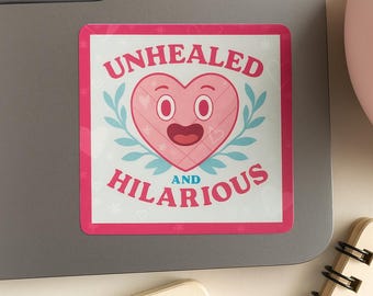 May include: A square sticker with a pink border and the words "UNHEALED AND HILARIOUS" in pink. The sticker features a smiling pink heart with eyes and a mouth, surrounded by blue leaves.