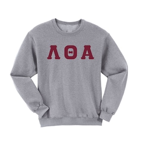 May include: A gray sweatshirt with a maroon Greek letter design that reads "ΛΘΑ".