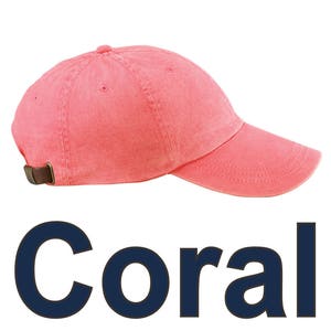 May include: A coral colored cotton baseball cap with a brown adjustable strap.