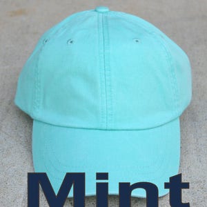 May include: A mint green baseball cap with a curved brim. The cap is made of a soft, cotton fabric.