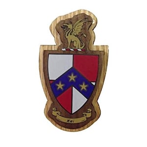 Puede incluir: Una placa de madera con un escudo y una cresta de dragón. El escudo está dividido en cuatro secciones: rojo, blanco, azul y blanco. La sección azul tiene cinco estrellas doradas. El dragón es dorado con ojos y alas rojos. La placa tiene la palabra "Kai" escrita en un rollo en la parte inferior.