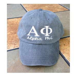 May include: A gray baseball cap with white embroidery that reads "AΦ Alpha Phi".