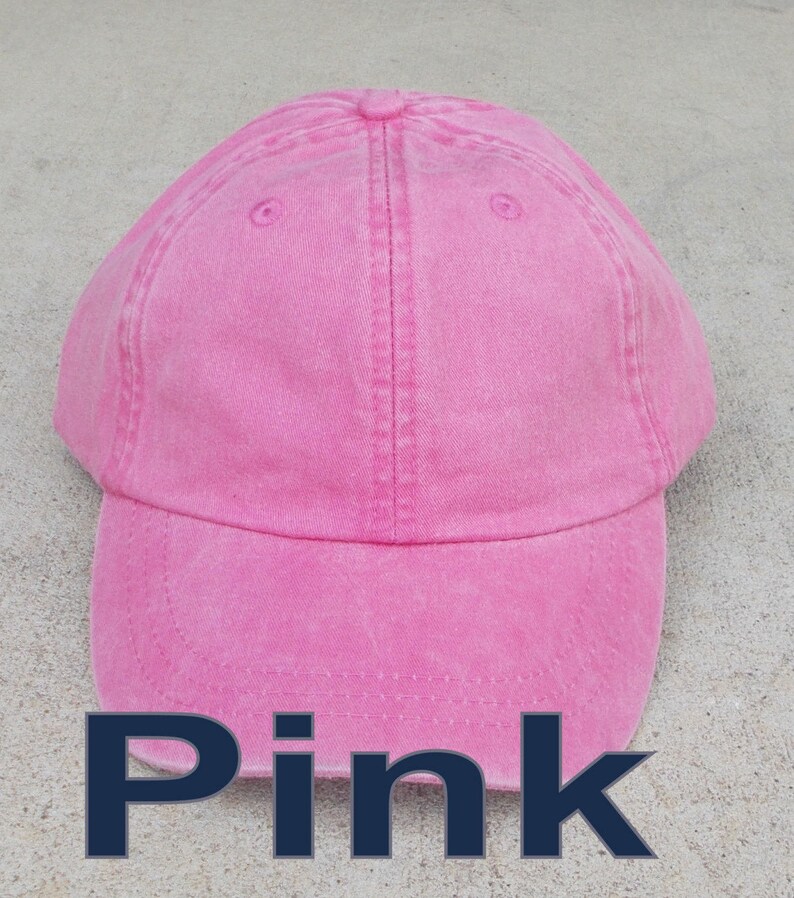 May include: A pink cotton baseball cap with a slightly distressed look. The cap has a curved brim and an adjustable strap.
