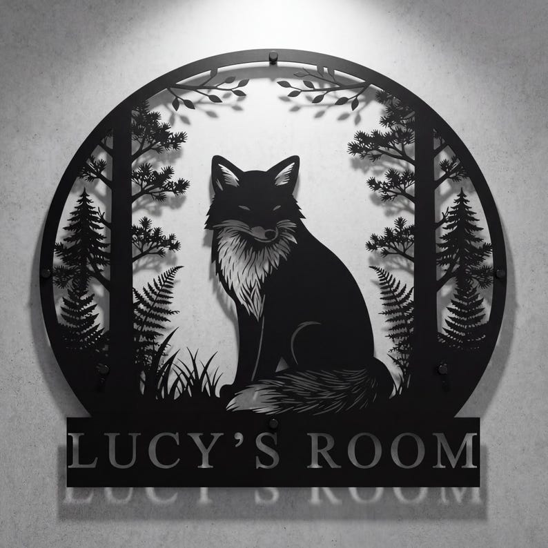 May include: Black metal wall art featuring a fox in a forest scene. The fox is centered within a circular frame with trees, ferns, and foliage. The text "LUCY'S ROOM" is displayed below the circular frame.