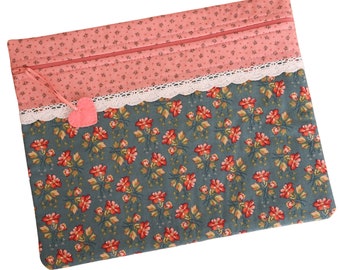 May include: A pink and blue fabric zippered pouch with a lace trim and a small pink felt heart attached. The pouch has a floral pattern.