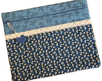 May include: A blue and white fabric zippered pouch with a lace trim and a small blue heart charm.