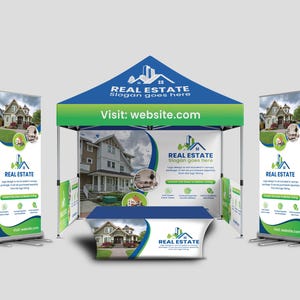 May include: A real estate exhibition stand with a blue and green canopy, two roller banners, and a table. The stand features the text "REAL ESTATE" and "Visit: website.com". The banners and table display images of houses.