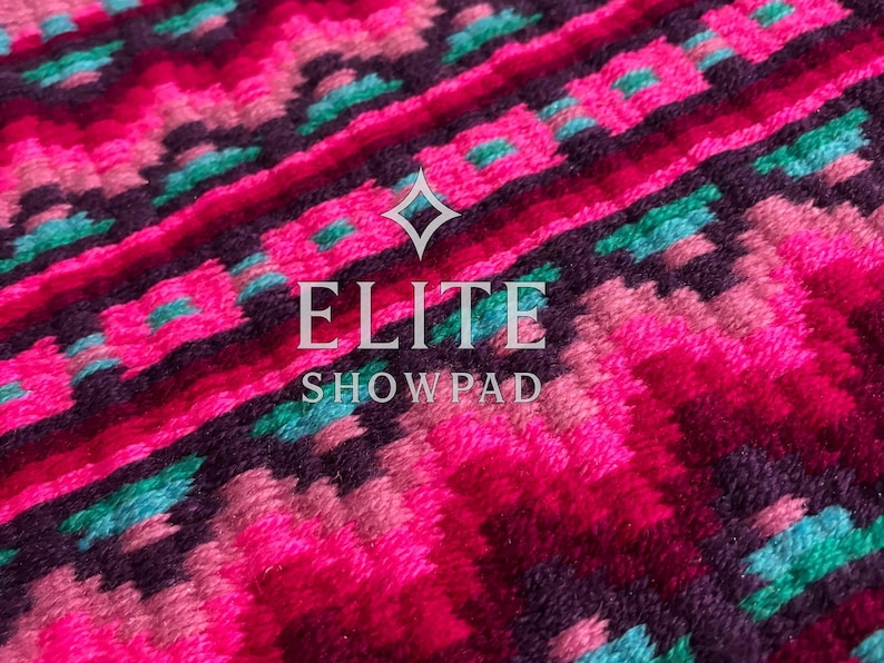 May include: Close-up of a vibrant, patterned textile. The design features a repeating geometric pattern in shades of pink, teal, and purple. The text "ELITE SHOW PAD" is centered on the image. The textile appears to be a show pad.