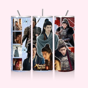 May include: Three stainless steel tumblers with images of Asian men in traditional attire. The tumblers feature a light blue, white, and red background. The text "Marquis Wu'an" is visible on one of the tumblers. Each tumbler has a silver straw.
