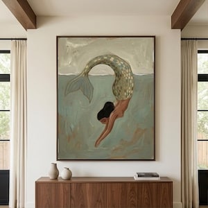 Könnte beinhalten: Abstrakte Malerei einer Meerjungfrau, die unter Wasser taucht. Die Meerjungfrau hat einen grün-goldenen Schuppenschwanz und schwarzes Haar. Das Kunstwerk ist in einem dunkelbraunen Rahmen gerahmt und hängt an einer weißen Wand.